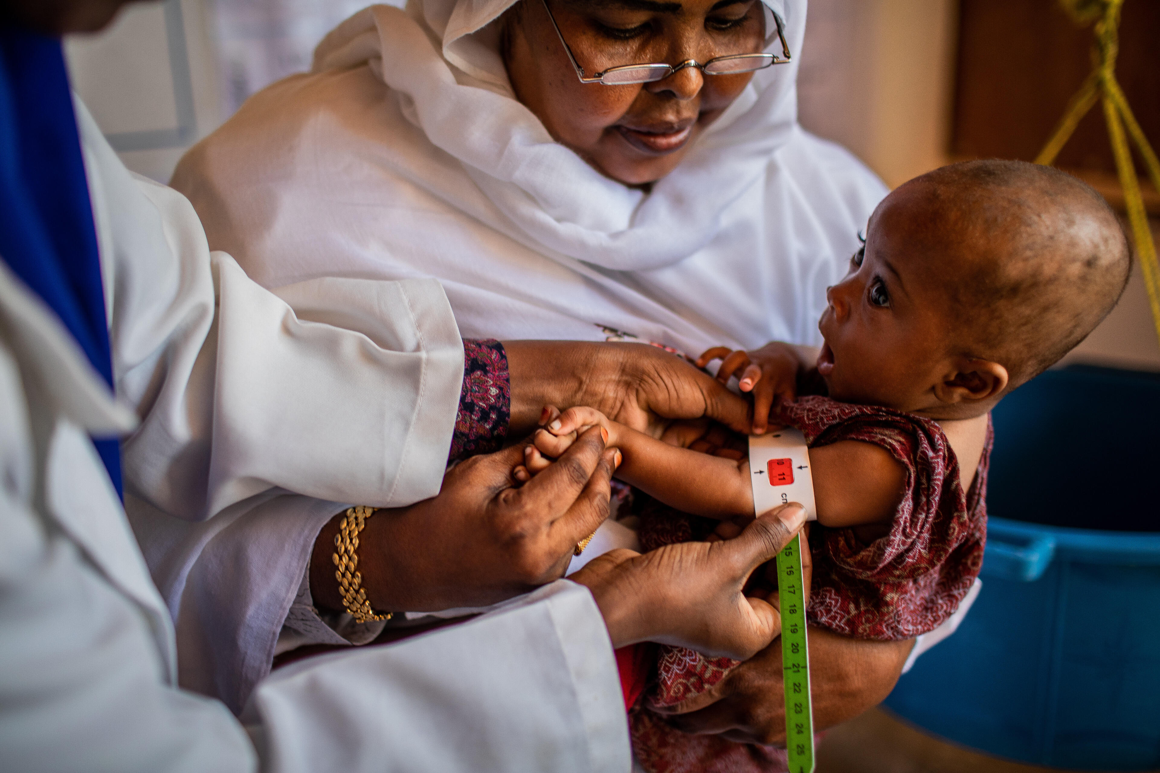 A health worker in Somalia measures a baby's upper arm with a special measuring tape to check for signs of malnutrition.
